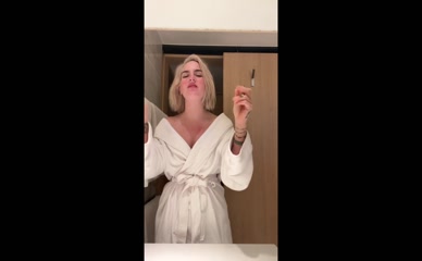 Joanna Jojo Levesque applying lipstick in bathrobe