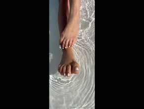 mrfrenchcouple female feet with white toe polish in water