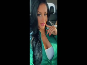 Miss West unzips her tracksuit top to reveal cleavage