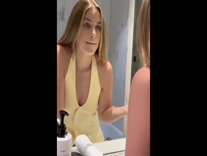 Teagan Croft applying lipstick in bathroom mirror.