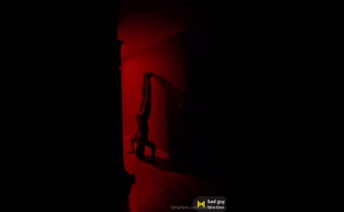 Nude chefcyrus does a handstand against a wall.