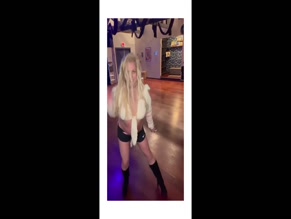 Britney Spears dances in shorts and tied top, exposed midriff