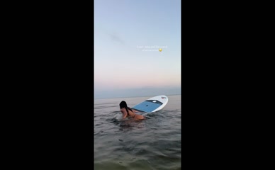 Mia Khalifa struggles to get on paddleboard in bikini.