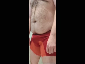 Man in underwear adjusting bulge.