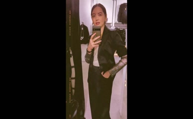 Jane Douglas mirror selfie in black suit.