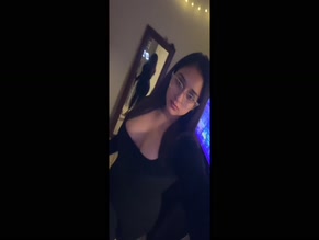Hispanic hot woman teasing her cleavage in a black dress
