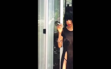 Bai Ling nude smoking in sheer dress.