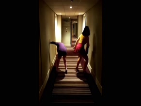 Two women twerking in a hotel hallway