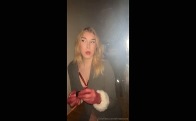 Allyssats applies lip gloss in red gloves.