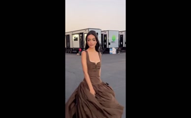 Rachel Zegler twirling in brown dress.