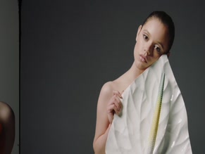 Jenna Ortega bare torso, chest covered by prop