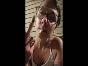 xilbabe smoking, extends middle finger, chest visible in low-cut top, OnlyFans