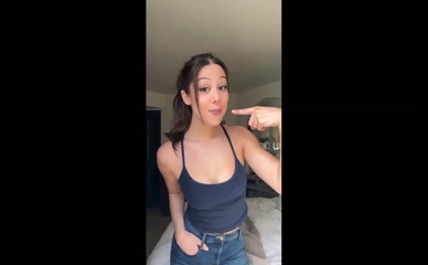Kira Kosarin teases cleavage in tank top.