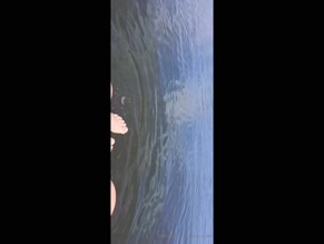 Feet dangling in lake water.