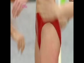 Alex Jones Bikini-clad, body covered in cling film, egg, and flour for games.
