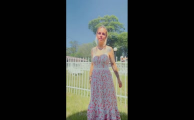 Tattooed blonde in floral dress shows cleavage.
