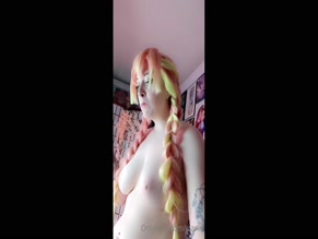 Nude starlis eats a sandwich.