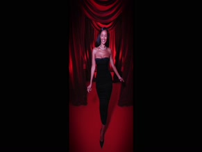 Maya Jama topless in black dress.