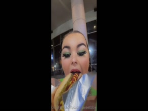 Sugarsweetbbwfree eats a hotdog.