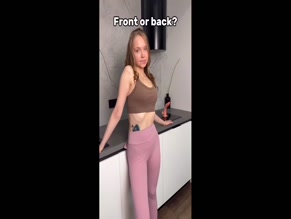 Baby Riley: Adult woman in form-fitting activewear, emphasizes glutes, dildo displayed.