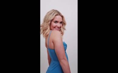 Blonde in blue dress twirls and smiles