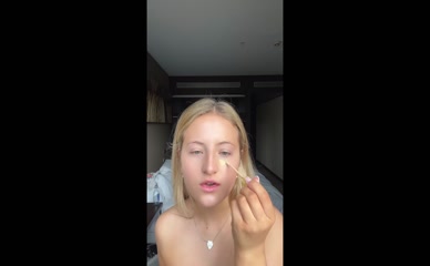 Daisy Campbell: Shoulders, upper chest, and midriff exposed during makeup application