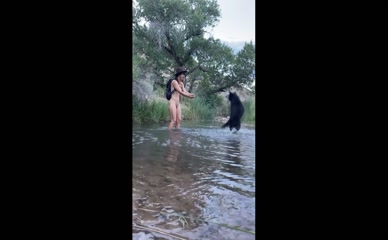 Nude lil_jenners plays with dog in river.