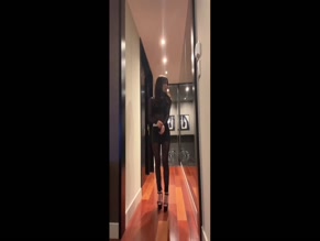 Jenna Ortega black sheer top revealing torso and sheer leggings revealing legs